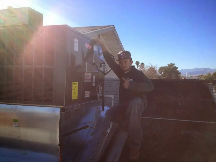 HVAC technician performing Heat Pump Repair on a rooftop unit in Westmoreland